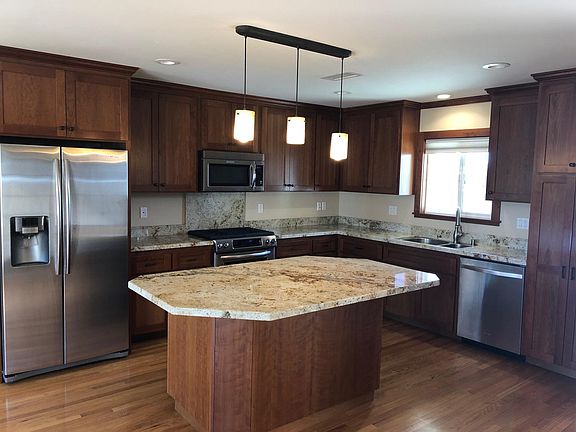 Kitchen and family room completely open. Wine refrigerator on other side of island.