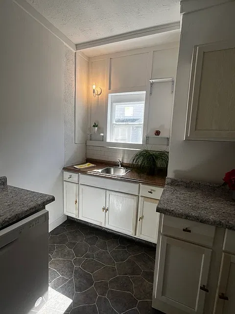 White kitchen cabinets & sink with window