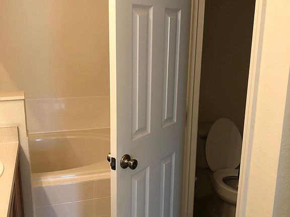 Tub and private toilet in en suite master bedroom