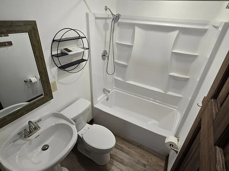 Full bathroom in hallway off of kitchen.