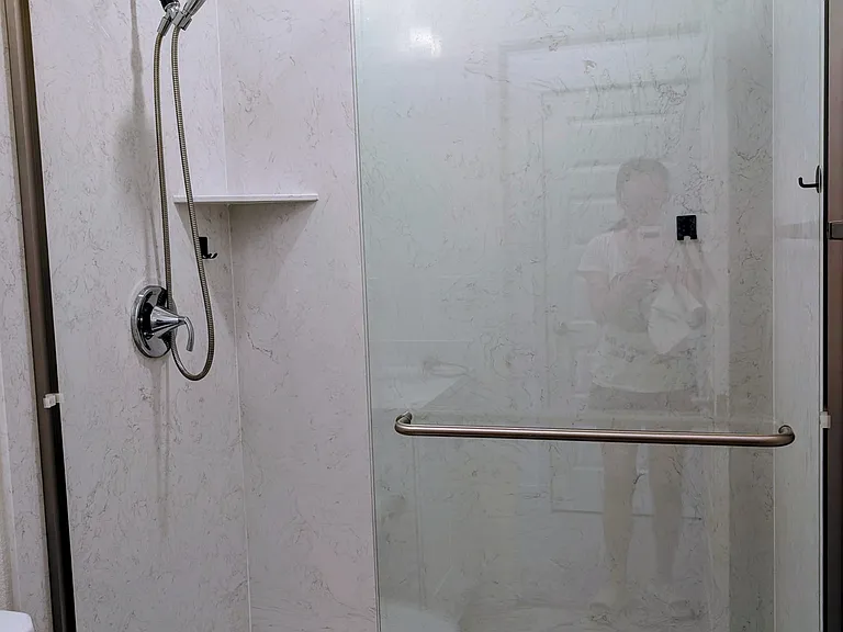 Modern glass-enclosed walk-in shower with a high-pressure showerhead and a chic utility hook to keep your daily shower essentials neatly organized.