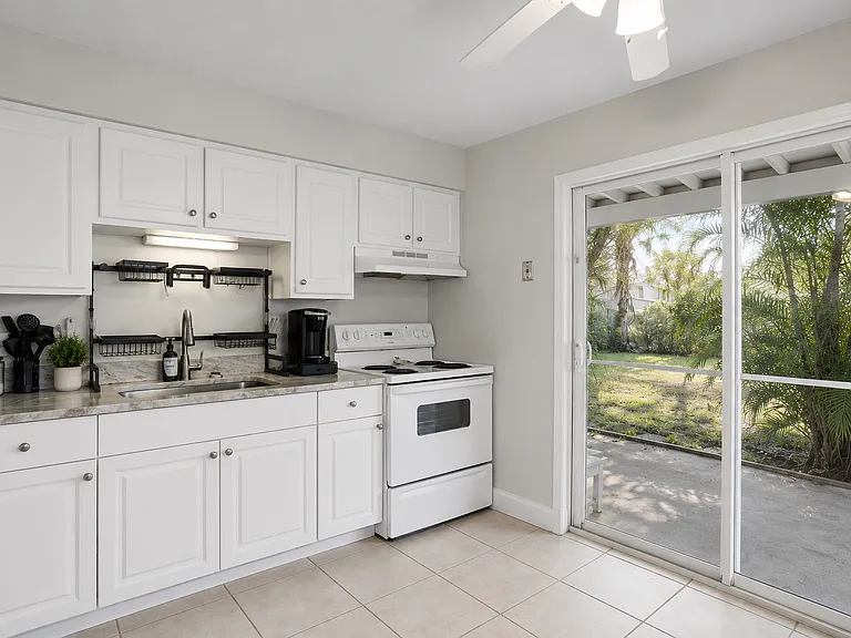 The kitchen is efficiently designed with modern cabinetry, ample counter space, and convenient access to the living and dining areas