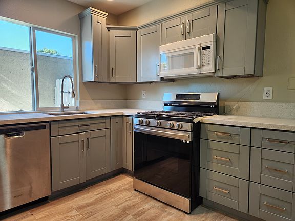 kitchen with gas range, stainless steel dishwasher, quartz countertops