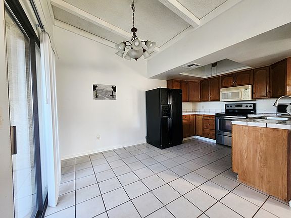 Vaulted ceilings in the kitchen and dinning area with easy to maintain tile floors and counter tops