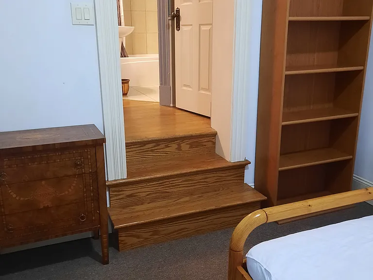 bedroom with stairs to living room