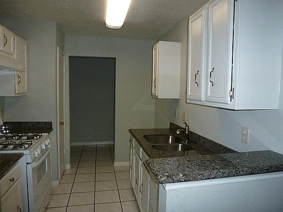 View of the kitchen looking in to in house laundry area with nice white tile in both spaces.