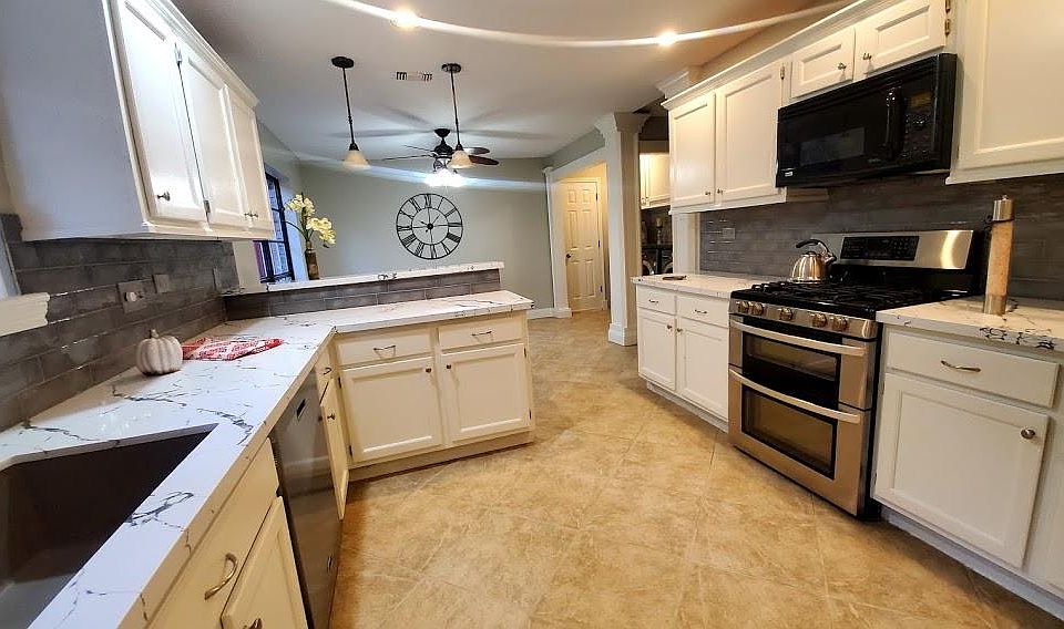 Kitchen is updated with high end Calacatta quartz, backsplash, and single bowl quartz deep sink.