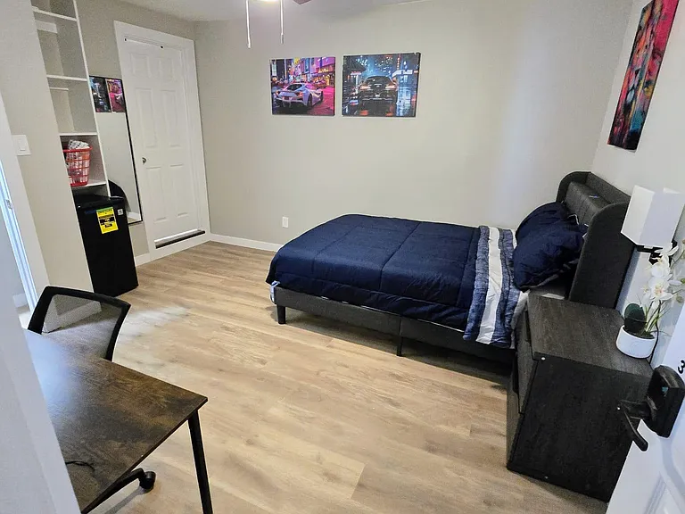 Room with private bathroom, full bed w/linens, mini-fridge, nightstand, work desk/chair, mini-split, ceiling fan