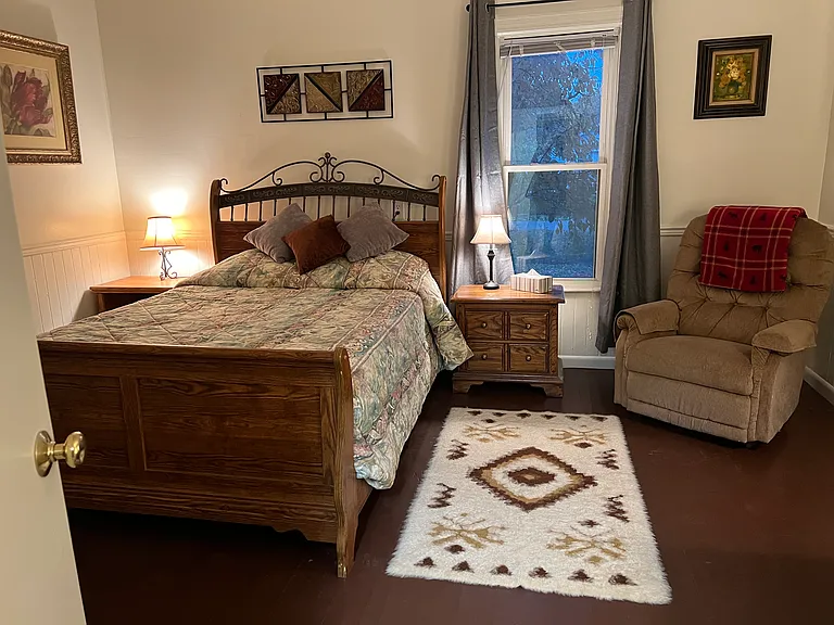 Bedroom with queen bed and recliner