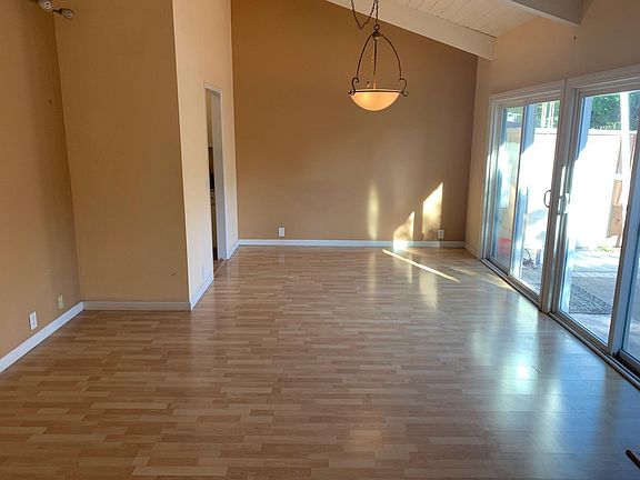 Dining room with vault high ceiling over looking the backyard and laminate floors.