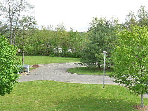 paved entrance w lawns and lighting