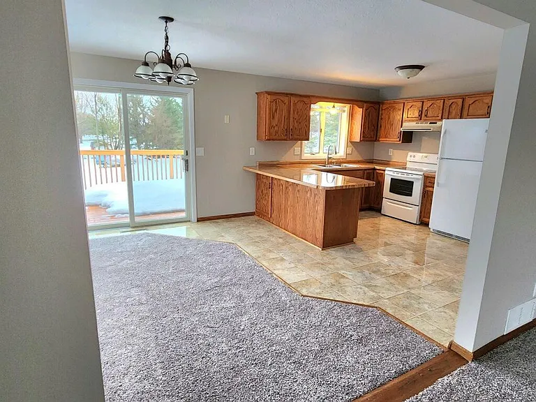 Kitchen and dining room. Sliding glass doors to back deck off dining room.