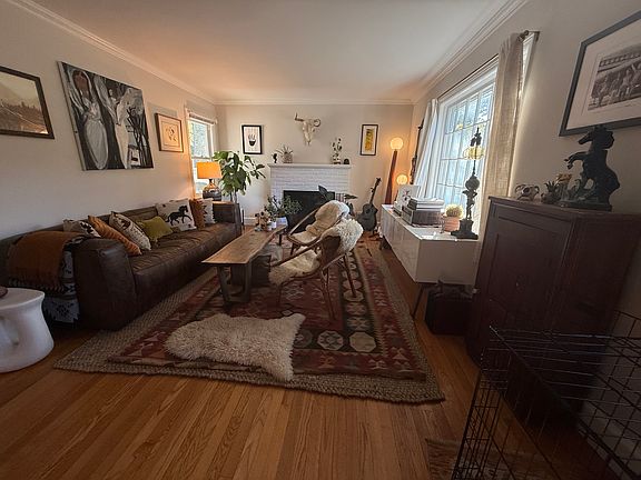 Large living room with hardwood floors and wood burning fire place