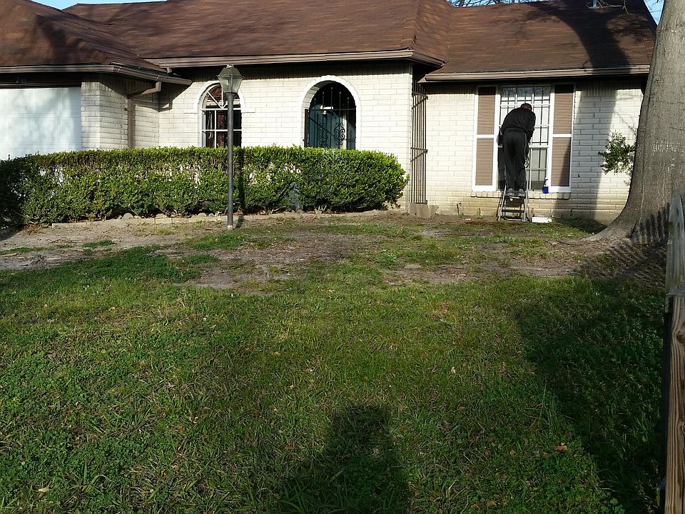 Front yard before large tree removal showing dinette window, front door entrance, and West bedroom window.