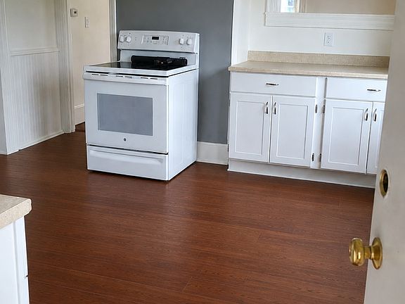 kitchen (includes fridge, stove). sink opposing side). new floors, paint and ceiling fan. Partially rendered photo as flooring is going in week of August 3rd.