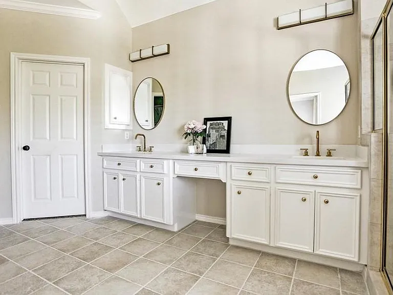 Master bathroom with double sinks, white quartz counter tops and gold fixtures gives this bathroom a glamorous update