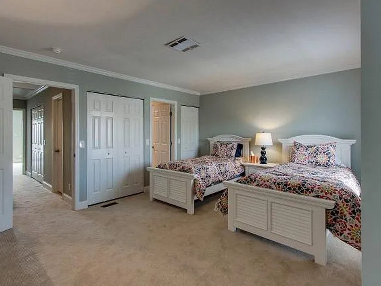 2nd Bedroom with two twin size beds large dresser, TV, and ensuite bathroom with shower.