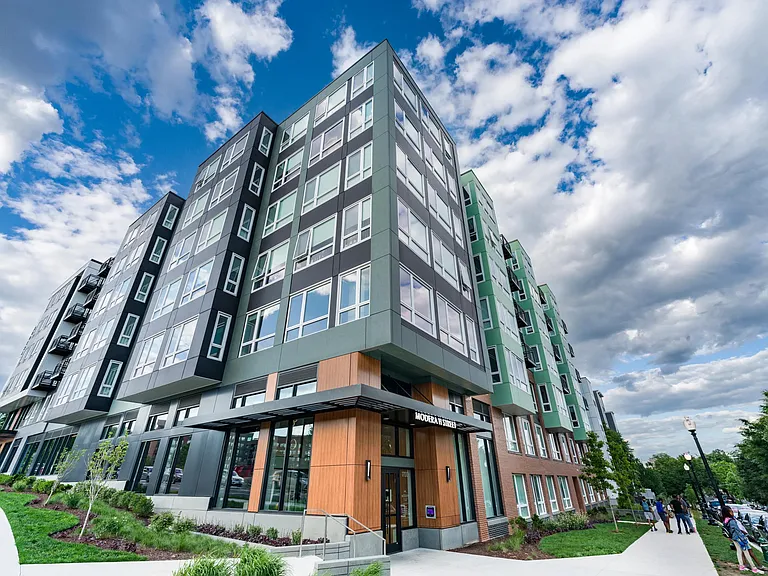 Corner view of the H Street community with layered facades, expansive windows, and street-facing design that connects seamlessly to the surrounding neighborhood.