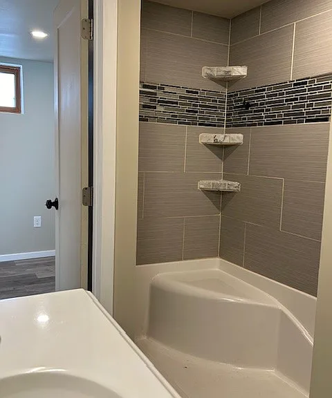 Large shower with seat, built-in shelves.