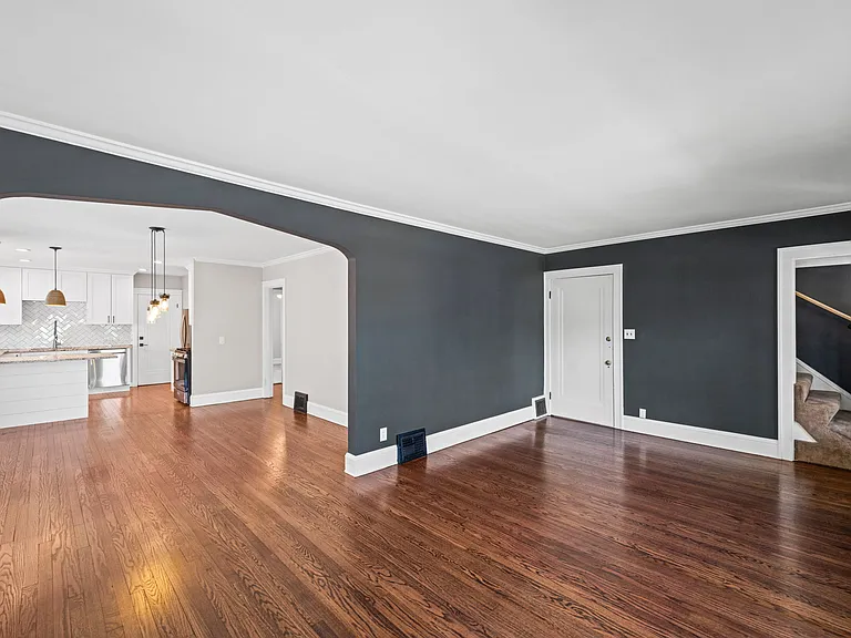 This photo shows the front entrance to the home that comes in the living room, as well as the steps that lead to the third floor.