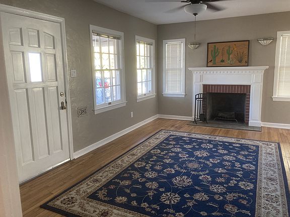 Living room with working fireplace and windows that bring in beautiful light
