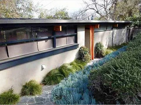Step down to the front door, which is behind a Sunbrella orange curtain panel.