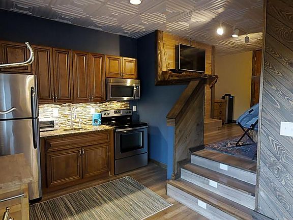 The Kitchen has full size appliances including a refrigerator freezer, electric glass top range and oven, a microwave and instant hot water. A movable cabinet creates extra counter space. There are lighted steps to the bedroom