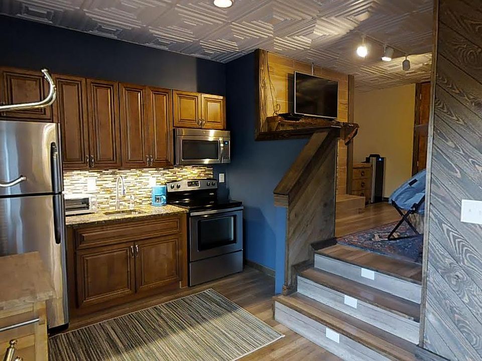 The Kitchen has full size appliances including a refrigerator freezer, electric glass top range and oven, a microwave and instant hot water. A movable cabinet creates extra counter space. There are lighted steps to the bedroom
