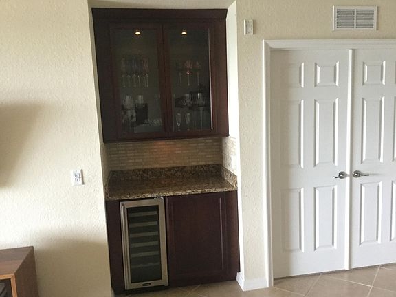 Beautiful bar with Marvel wine refrigerator, lighted upper glass cabinet and bottom cabinet with roll-out drawers.
