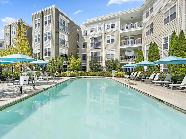 Outdoor Pool Area with Ample Seating and Umbrella-Shaded Loungers