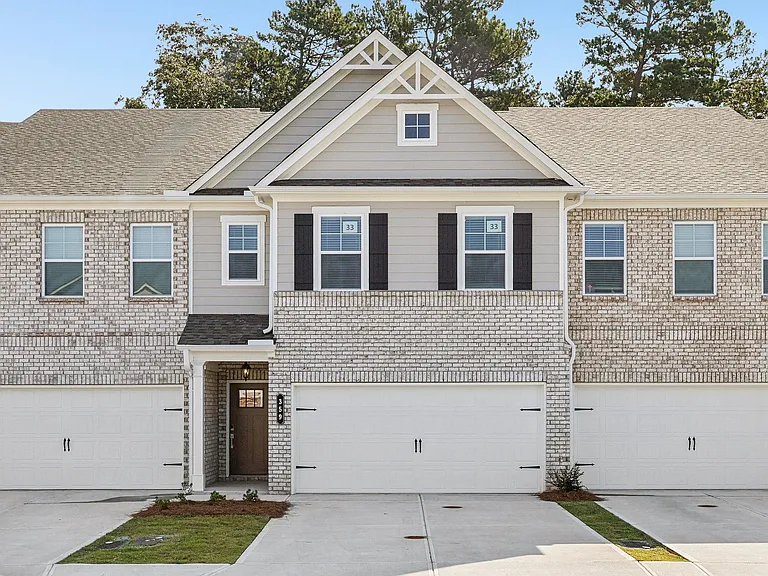 Exterior shot of the Westport floorplan, two story townhome with a private driveway and attached garage.