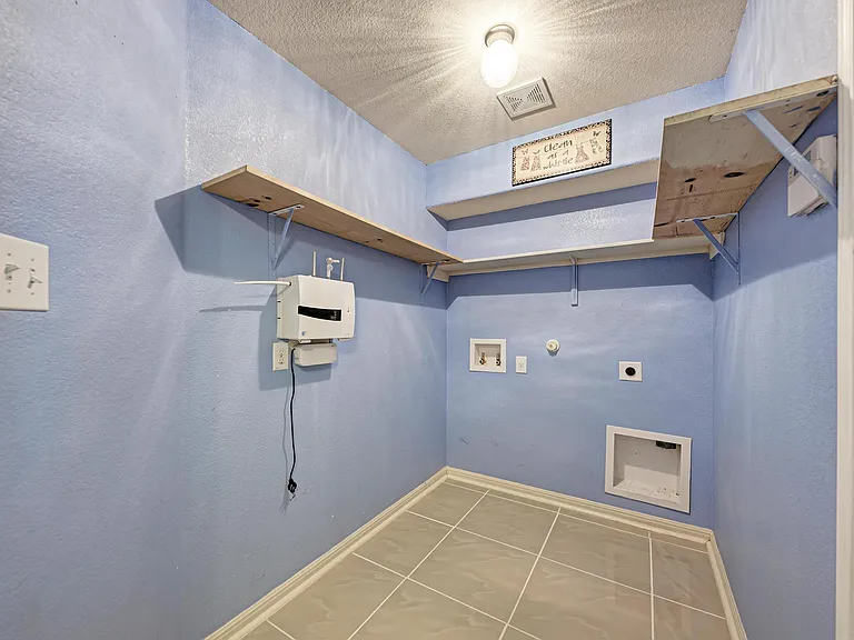 Laundry room that also leads to the garage. Security system available and plumbed for water softener.