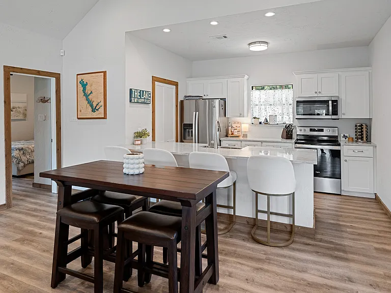 Stylish dining area with a high-top table for 4, plus 4 bar stools at the kitchen counter_perfect for casual meals and socializing.