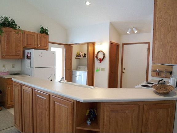 Kitchen with main floor laundry in the background, door to porch 