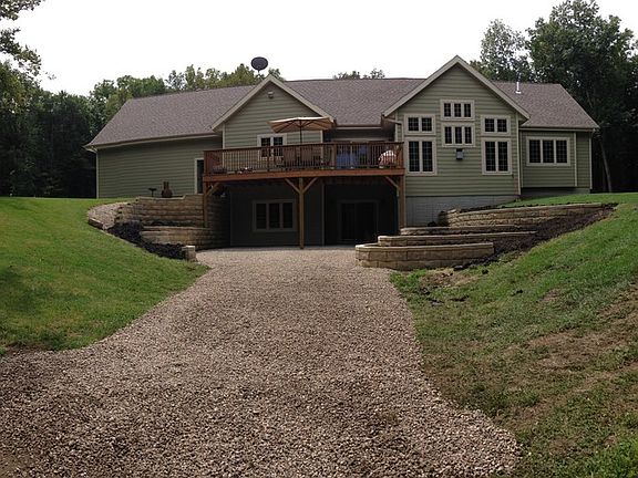 Back Exterior : Walk-out basement to patio beneath deck Several tiered flower/shrub gardens