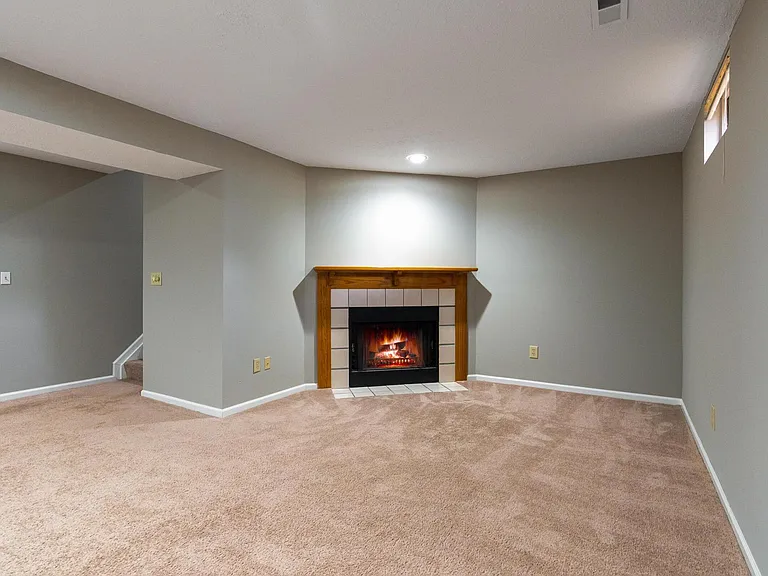 Basement recreation room with wood burning fireplace