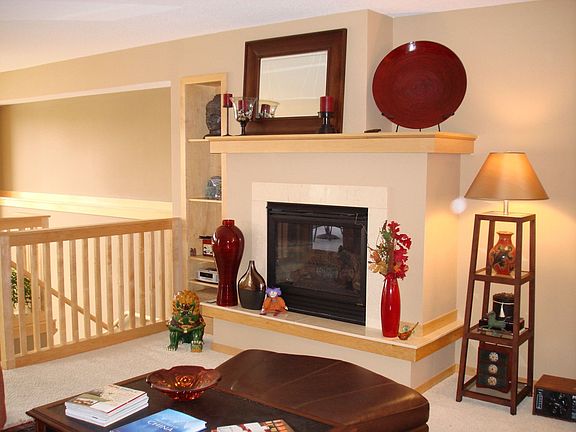 The living room has a gas fireplace and built-in maple bookshelves.