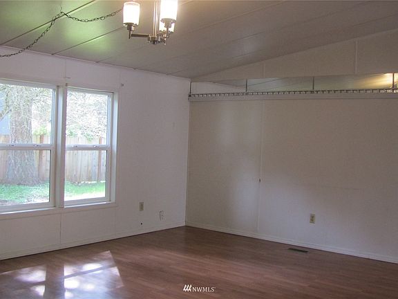 The living room is full of natural light with these large windows overlooking the side yard.
