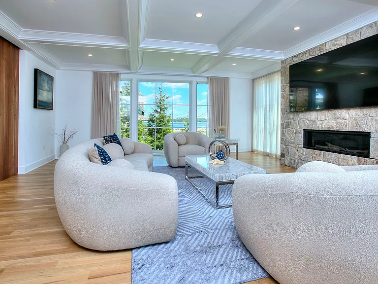 Living room with floor to ceiling windows showcasing panoramic views of Long Island Sound.