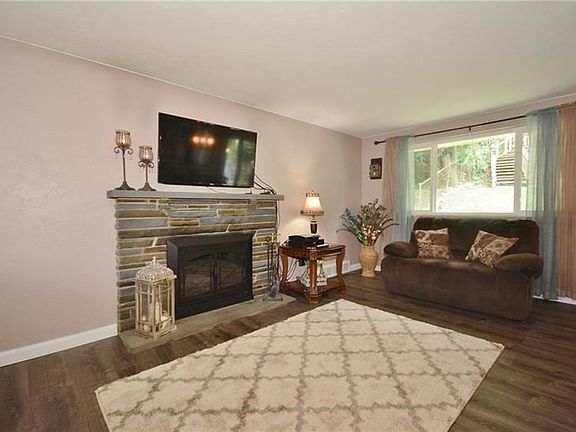 The fireplace provides a level of comfort plus sophistication to this warm and cozy living room with large NEW PELLA WINDOW!