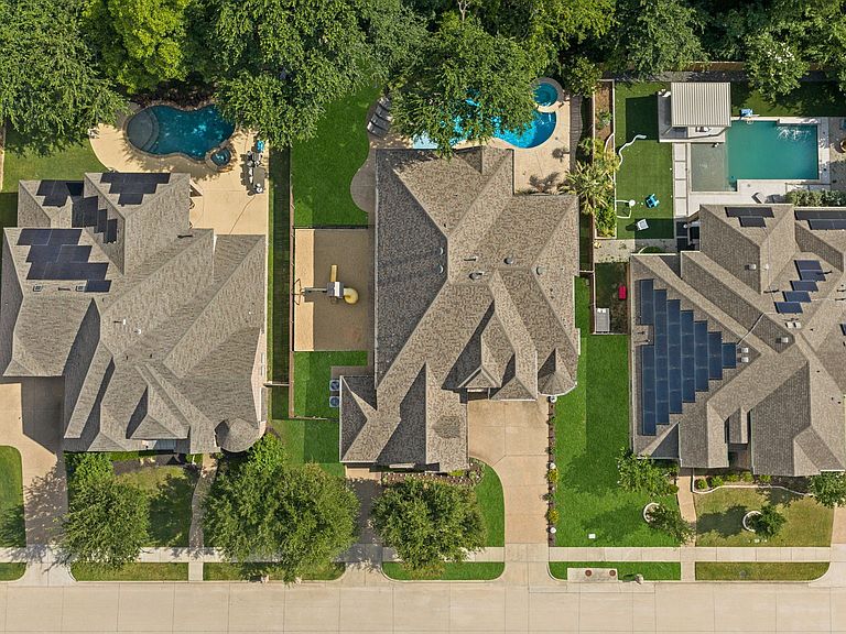 Grand entry of 8609 Tuscan Oaks Drive with a wrought iron staircase, hand-scraped wood floors, soaring two-story ceilings, and natural light from oversized windows