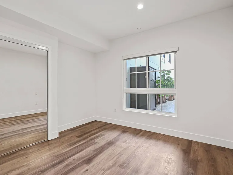 Bedroom with Mirrored Closet, Vinyl Flooring, Window, and Vinyl Flooring
