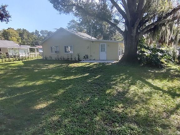Full view of backyard with shade tree