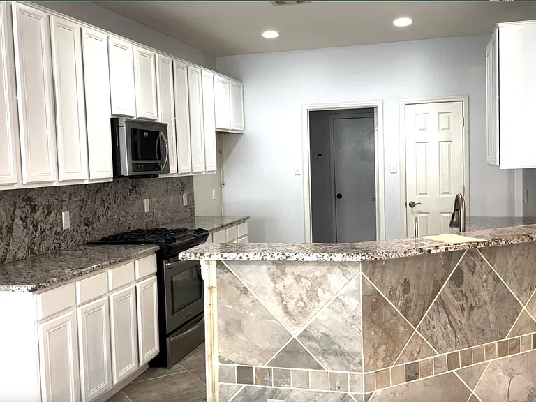 kitchen with granite counter top and modern white wood cabinetry