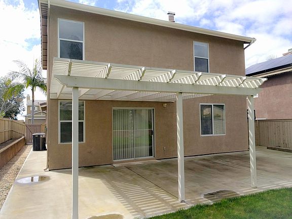 Covered patio and the AC unit at the side of the house.