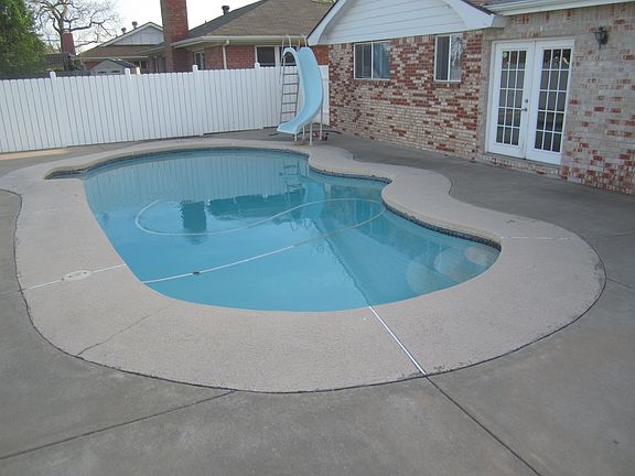 Back view of home and pool with slide