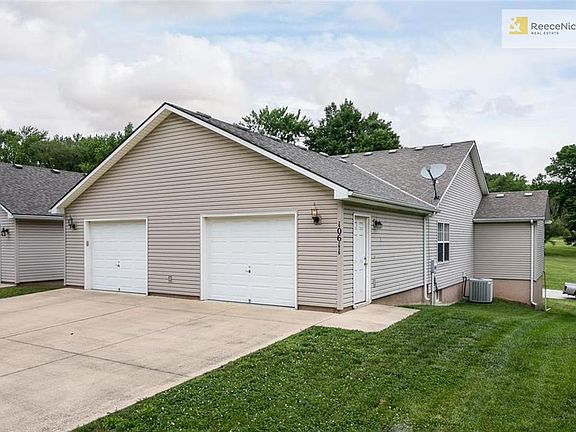 Driveway access around back of the house with a large concrete driveway and spacious 2 car garage. Plenty of room for 2 cars inside AND all your lawn care tools.