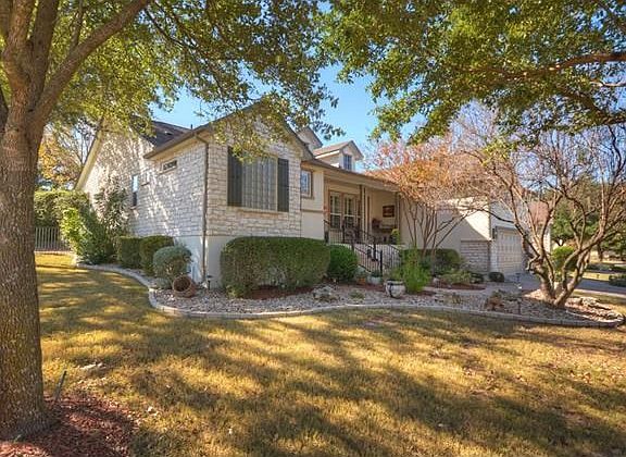 Curvy landscaping beds circle the hoe with pride, while the extra-wide lot allows for a Side-Entry Golf Cart Garage!
