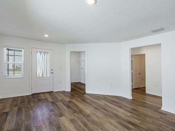 Foyer and dining room area leading to the home s kitchen and entertainment space.