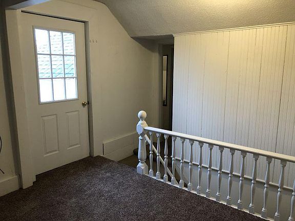 Entry/Common area. View from living room in entry/common area. Entry door leading to deck. Hallway to bathroom and bedroom 3. Ahead is a stairway this serves only as a fire exit.